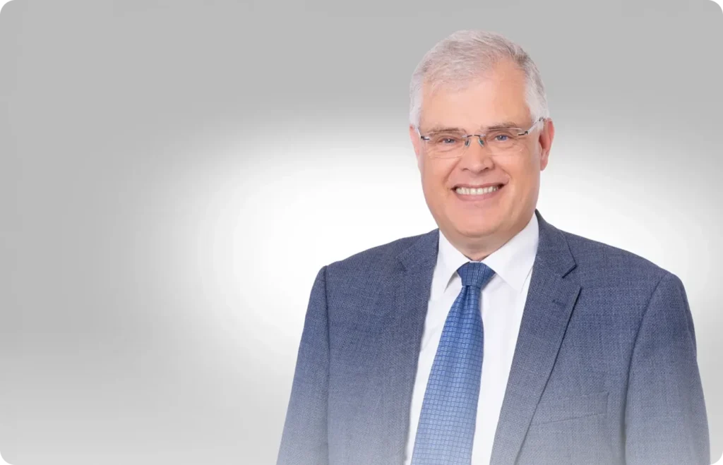 Rechtsanwalt Dr. Martin Ludwig im dunkelblauen Anzug vor neutralem Hintergrund.